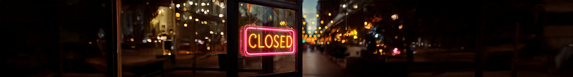 Neon 'CLOSED' sign in a city street at night
